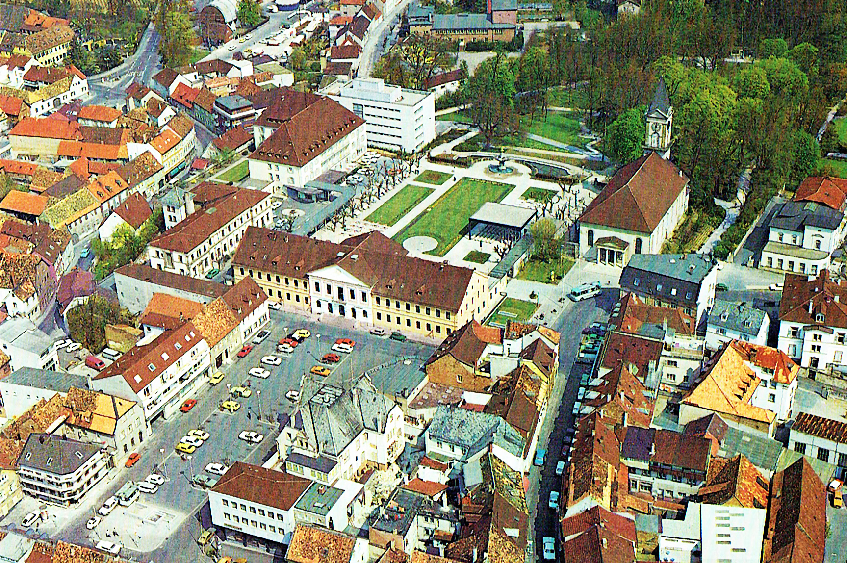 Figure 11: Luftbild von Schlossplatz und oberem Kurgarten mit Kurhaus, Kurmittelhaus, dem Kurparkhotel von 1937 und dem dahinter befindlichen Erweiterungsbau von 1972 noch mit Flachdach, welcher heute (2025) im Ansehen dem Hauptbau angeglichen worden ist. Im Hintergrund sieht man an der Stelle der heutigen Psychosomatischen Klinik die alte Turnhalle, die im August 1978 abgerissen wurde. Rechts der Ludwigskirche das elegante Hotel »Leininger Hof«, nach Abriss und grauslichem Neubau von 1979 heute das »Achat Hotel«. Die Kurgartenstraße ist noch keine Fußgängerzone. 1978.